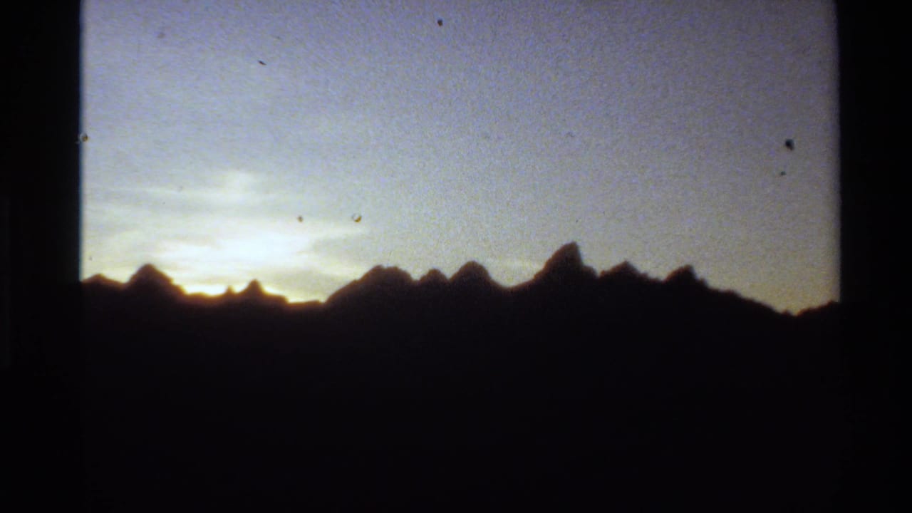 Mountain ridge in silhouette with a brighter glow near the horizon.