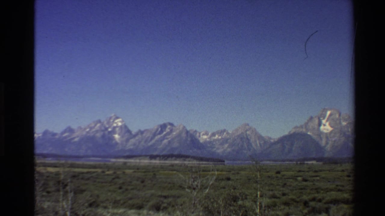 Mountain range and broad plain framed by dark 8mm film borders.