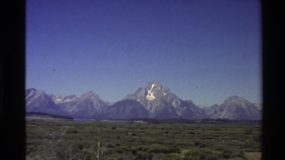 Final 1980 home-movie frame of the Teton Range across sagebrush flats in the Western United States.