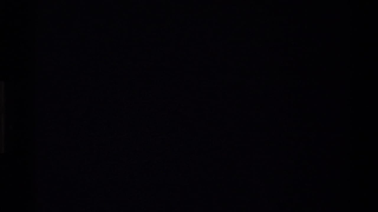 Dark 8mm frame from the start of a 1980 Western USA home-movie clip, with only faint film-edge shapes visible.
