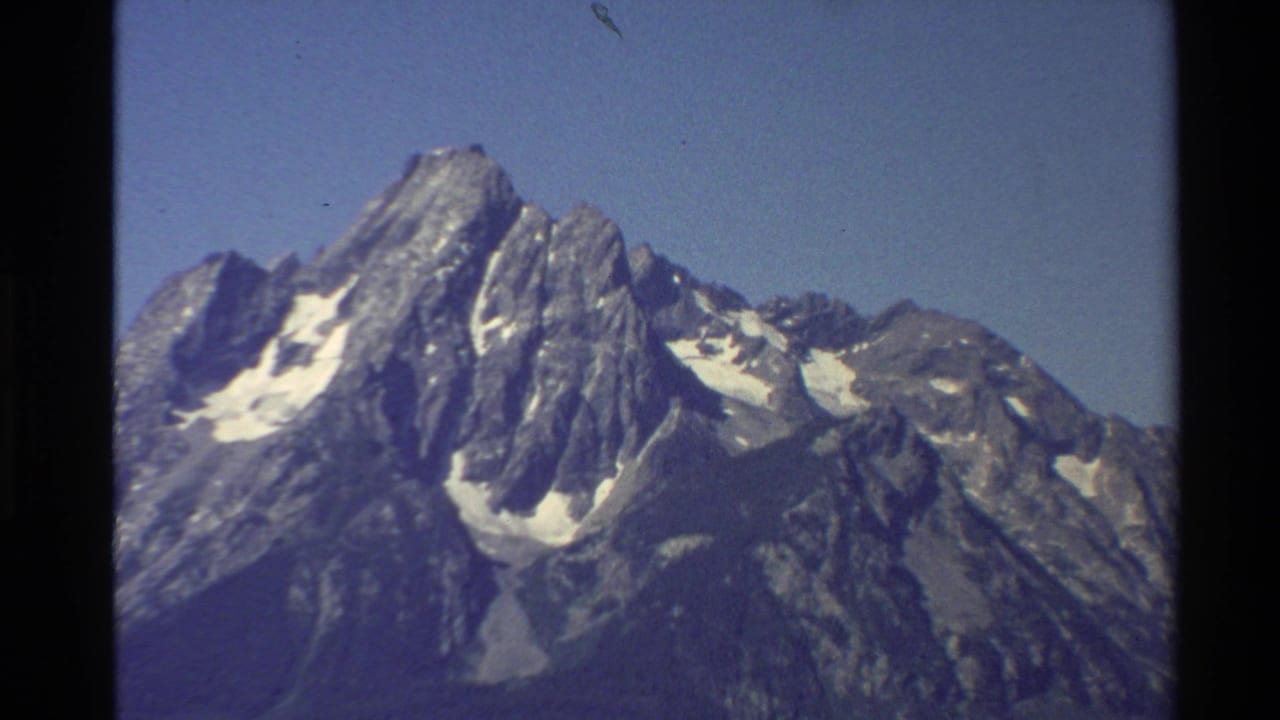 A similar 1980 8mm view of snow-streaked rocky peaks in the Western United States, framed by visible film borders.