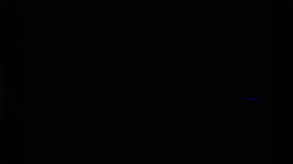 Dark 8mm frame from the same clip with heavy underexposure and only faint blue-black shapes visible.