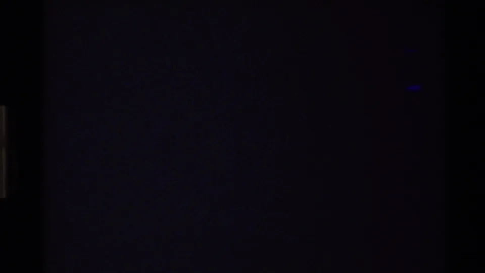 Dark 8mm frame likely from camera movement, film handling, or underexposure, with only faint color and edge marks visible.