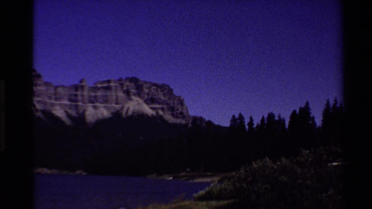 Same mountain and lake scene darkened under a purple twilight sky.