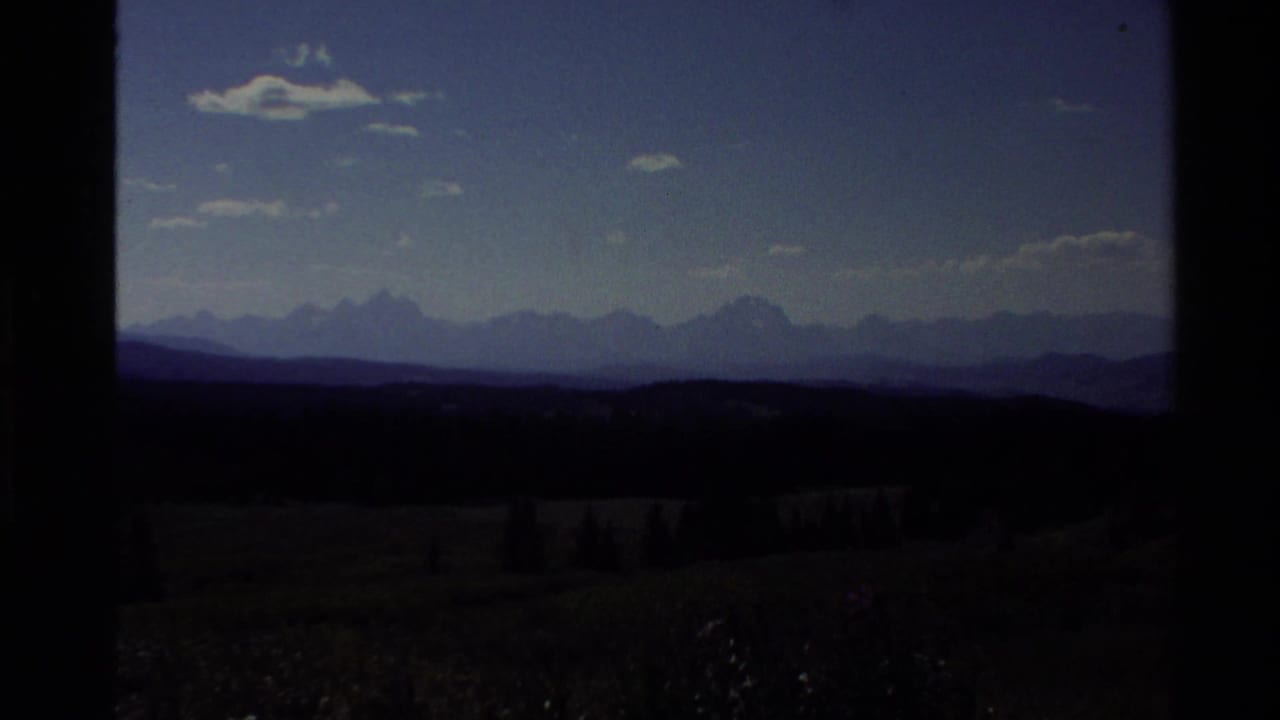 Darker view of distant mountain ridges under a deep blue sky.