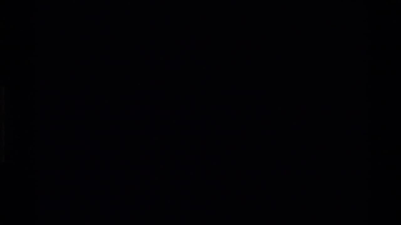 Very dark frame with faint vertical bands and minimal visible detail.