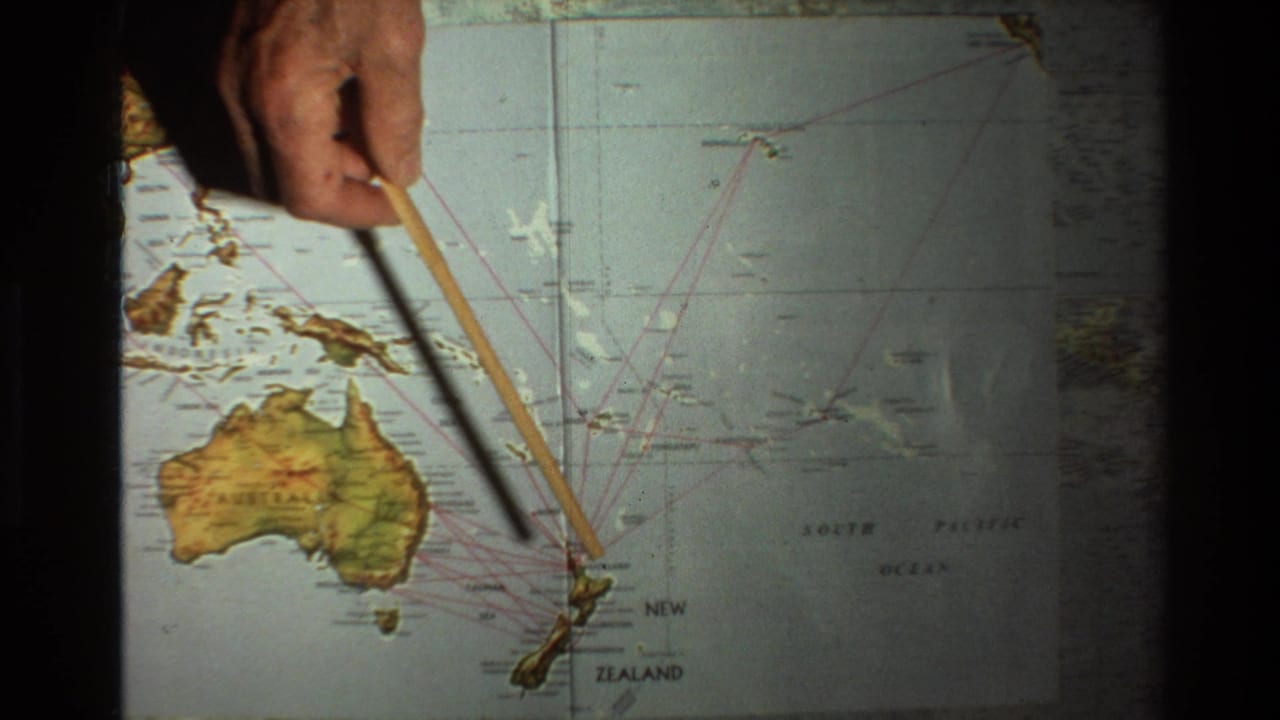 1981 8mm frame showing a hand using a wooden pointer on a Pacific map labeled Australia and New Zealand.
