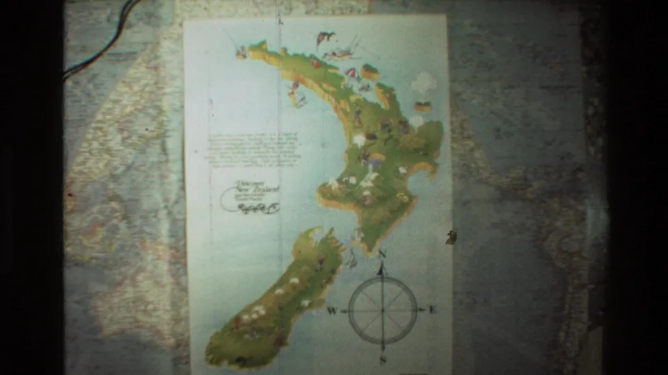 1981 8mm frame showing a colorful New Zealand map with a compass rose, set against a larger world map background.