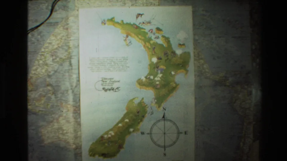 A soft 8mm frame shows the illustrated New Zealand map from a slightly lower angle, with the compass rose and surrounding world map still visible.