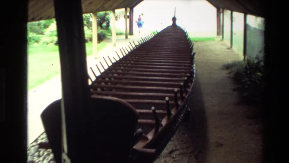 1981 New Zealand home-movie view down a sheltered waka, with a distant visitor near the bright opening.