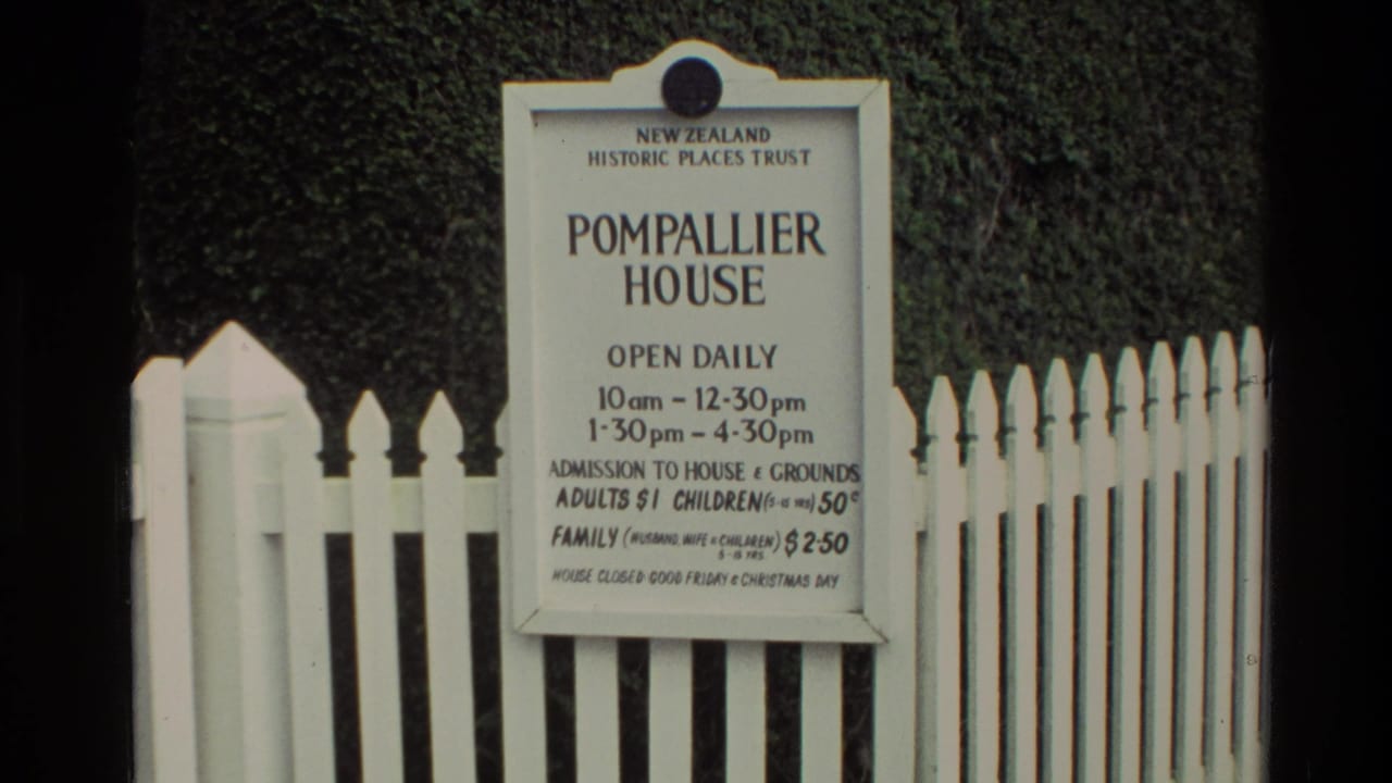 1981 New Zealand 8mm frame showing the Pompallier House admission sign mounted by a white picket fence.