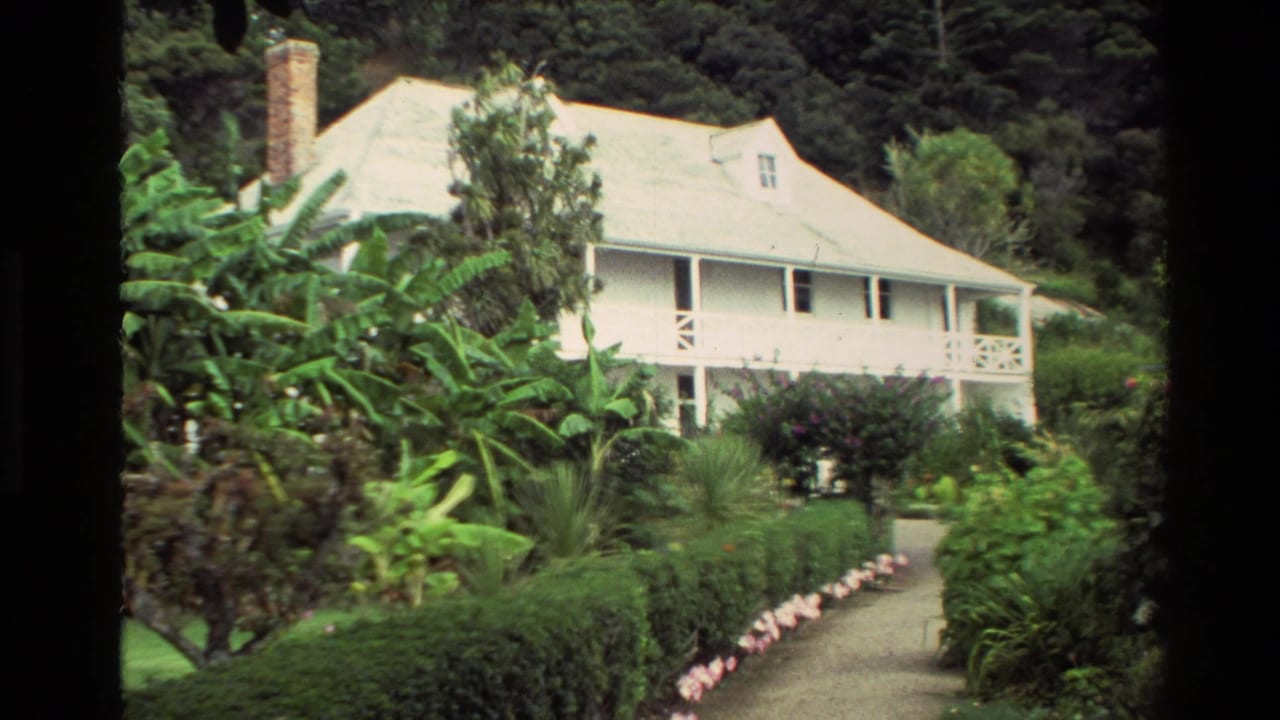 1981 New Zealand 8mm view of Pompallier House set among dense garden planting and a path leading toward the veranda.