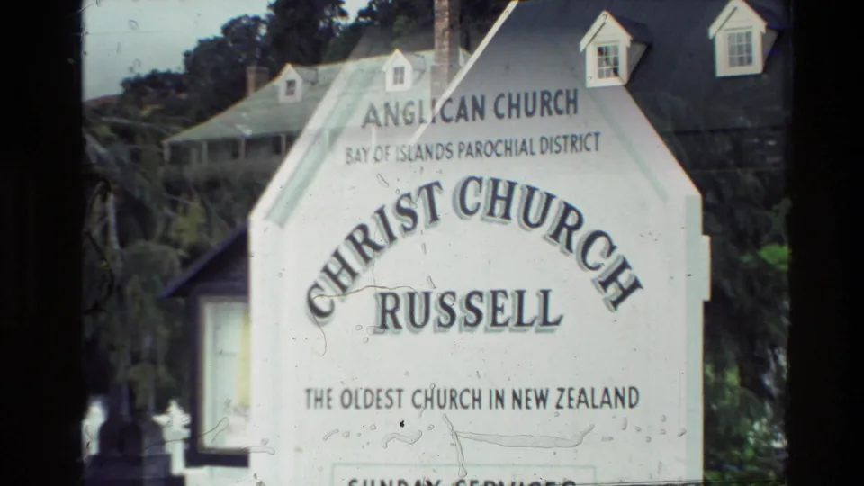 Church sign reading Christ Church Russell, Anglican Church, Bay of Islands Parochial District, in a 1981 New Zealand home-movie frame.