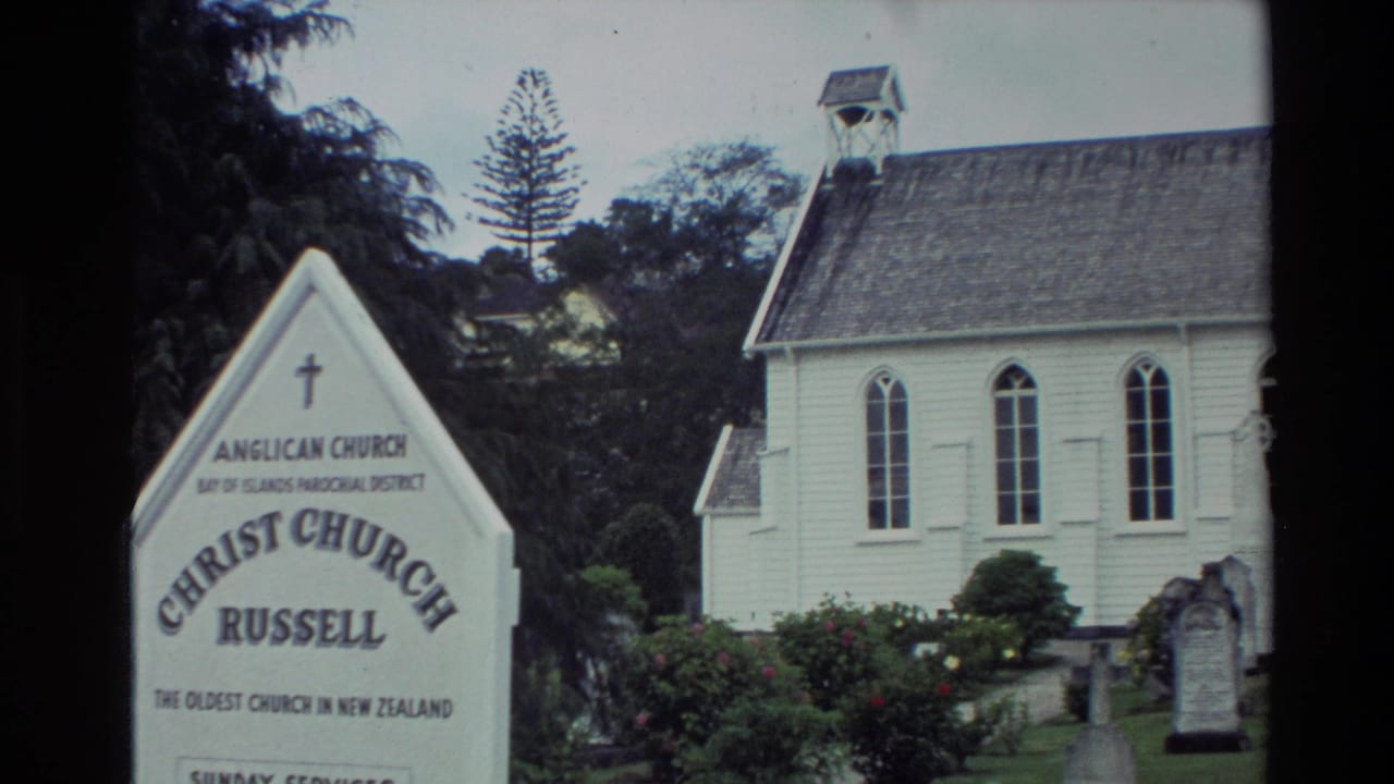 Christ Church Russell sign beside a white timber church and cemetery grounds.