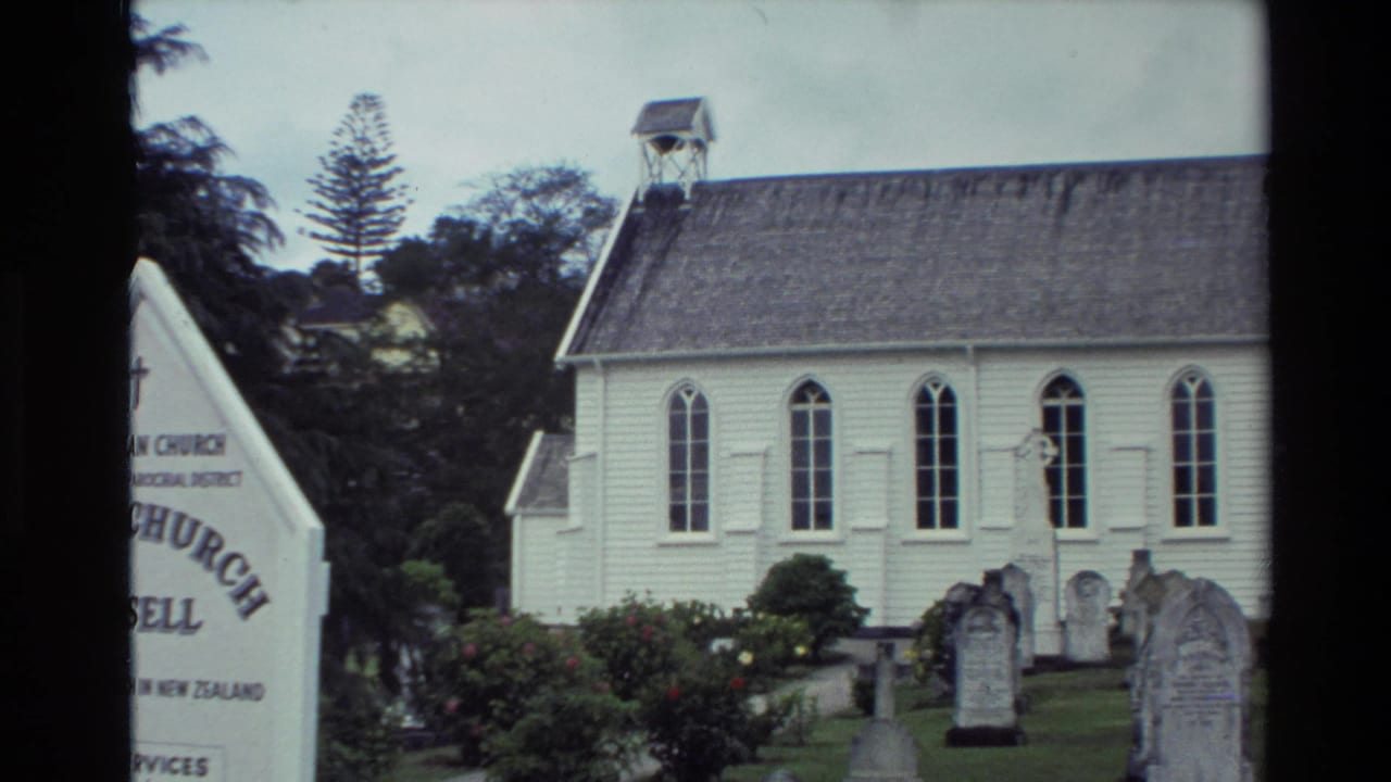 Visitor-shot 1981 view of Christ Church Russell with its white facade, arched windows, cemetery headstones, and partial entrance sign.