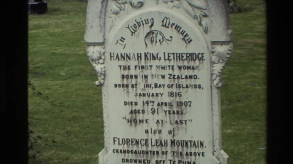 1981 New Zealand 8mm frame showing a white carved memorial stone for Hannah King Letheridge in a cemetery lawn.