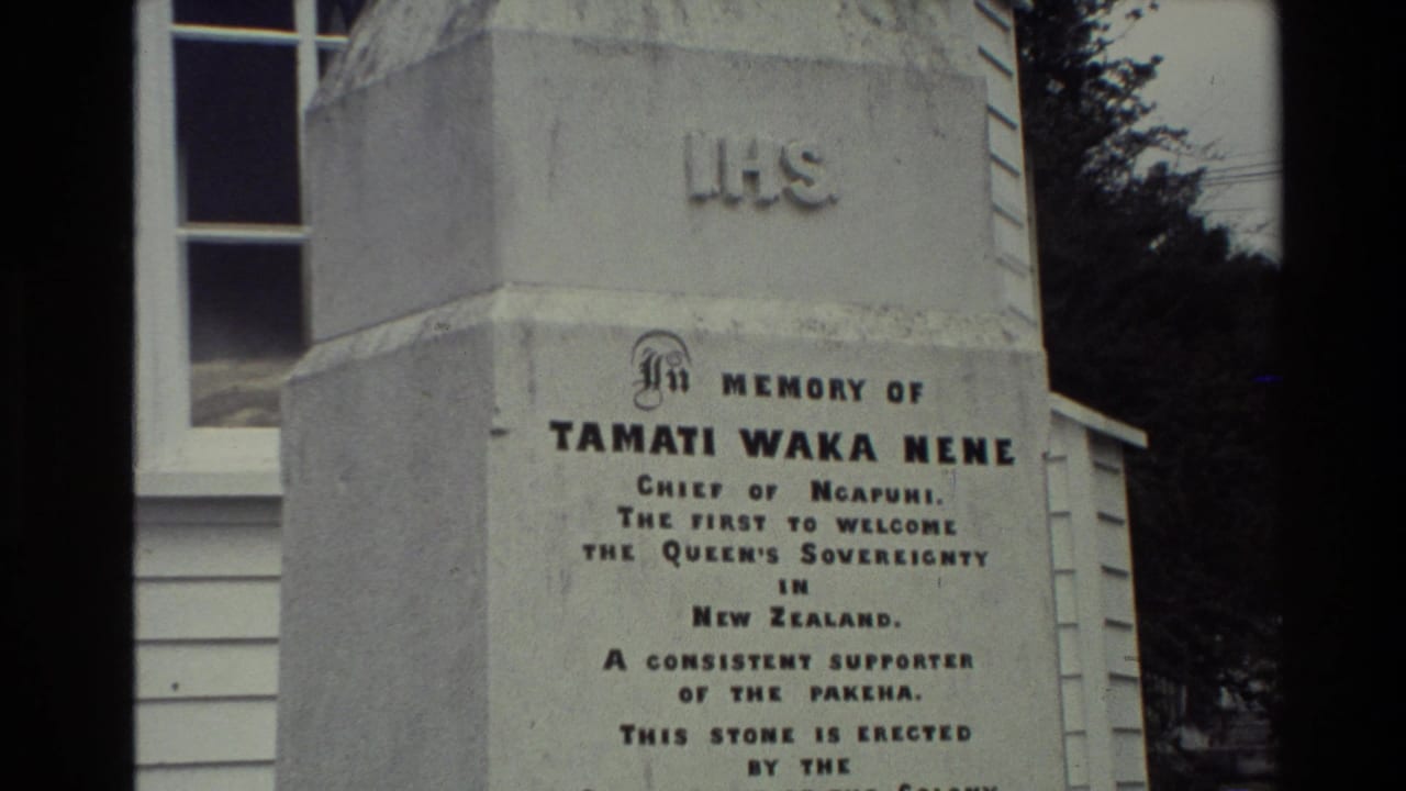 1981 New Zealand 8mm frame showing a white obelisk memorial for Tamati Waka Nene beside a weatherboard building.