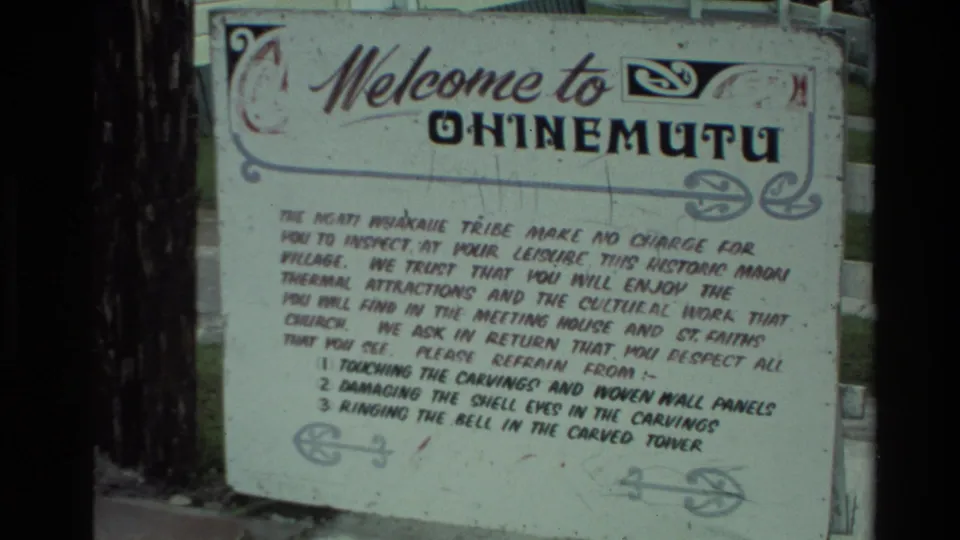 The Ohinemutu welcome sign fills the frame, showing decorative lettering and visitor guidelines in faded 8mm color.