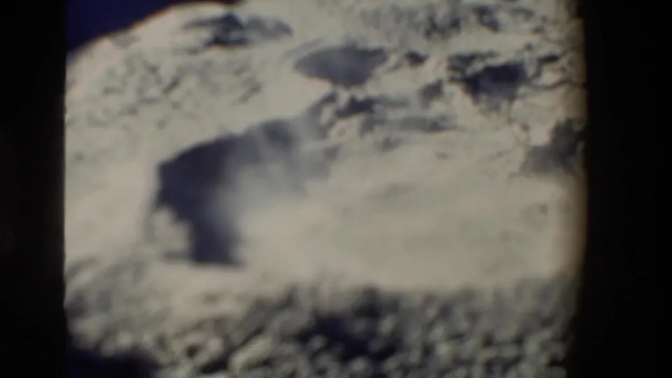 1981 New Zealand 8mm frame showing a soft-focused geothermal surface with pale mineral ground, dark openings, and low steam.
