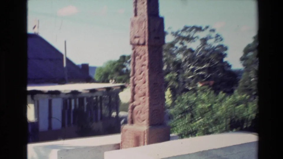 1981 New Zealand travel frame with a carved monument in front of a low church-like building and surrounding trees.