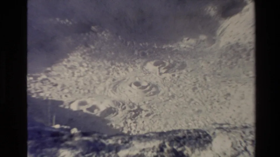 1981 New Zealand home-movie frame showing boiling volcanic mud with ripples, bubbles, haze, and small-gauge film edges.