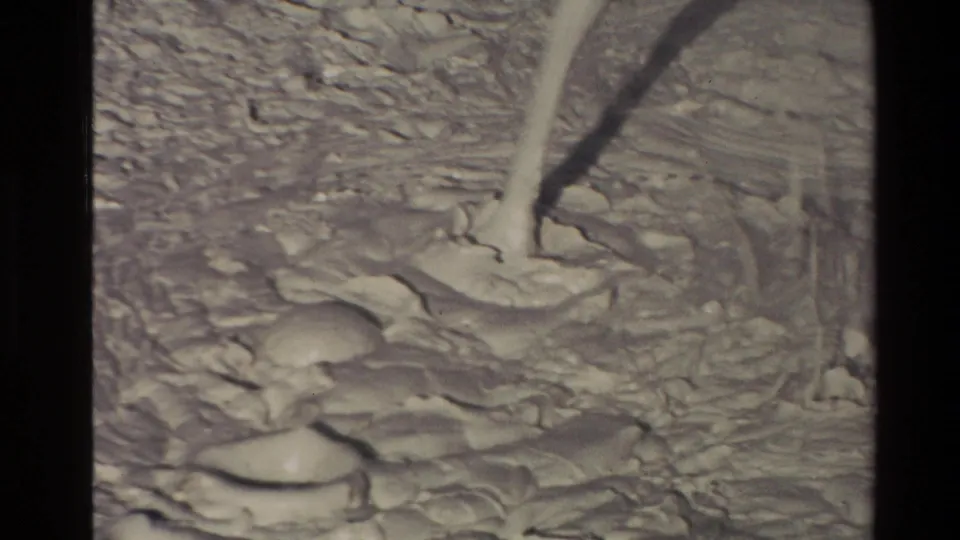 1981 New Zealand frame showing a pale mud splash rising from an active mud pot, surrounded by rippled wet volcanic mud.