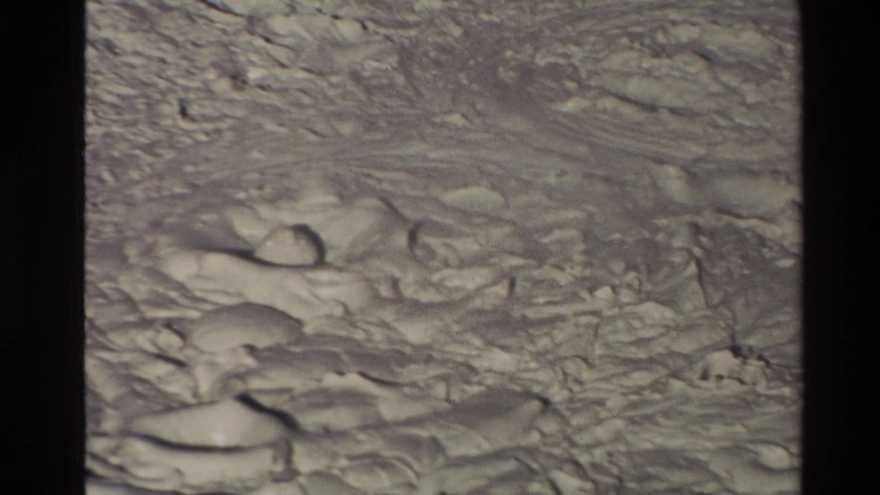 Close view of pale bubbling mud surface with dark frame borders.