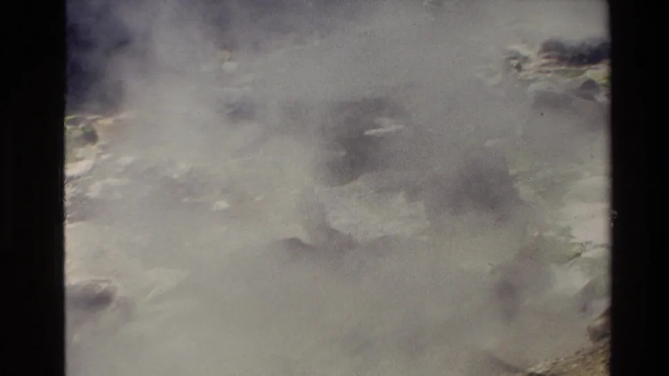 Steam obscures much of a rocky geothermal surface in this 1981 New Zealand 8mm travel frame.