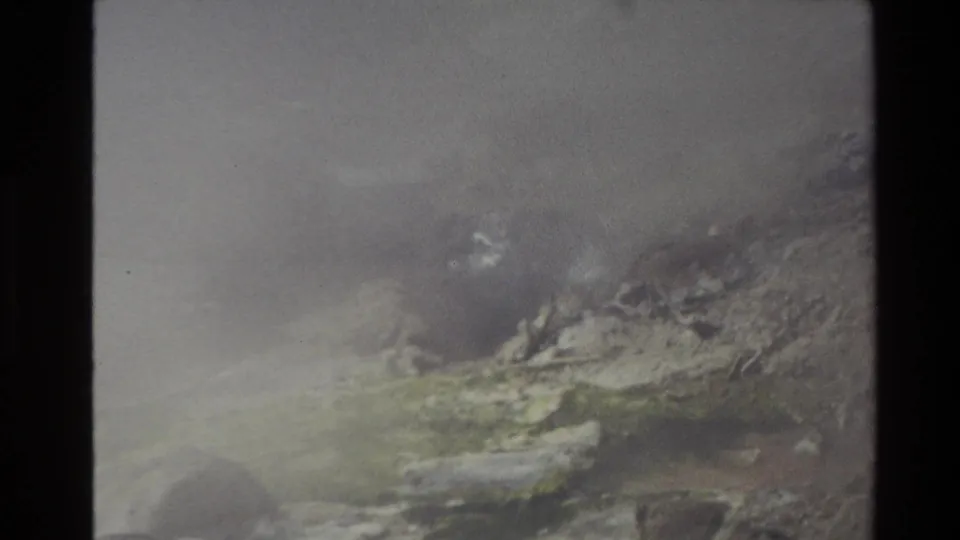 1981 New Zealand 8mm frame showing steam over rocky geothermal terrain with muted mineral colors and soft exposure.