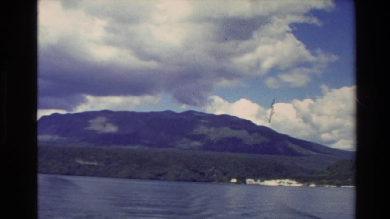 Lake beneath dark mountain ridges and a cloudy sky.