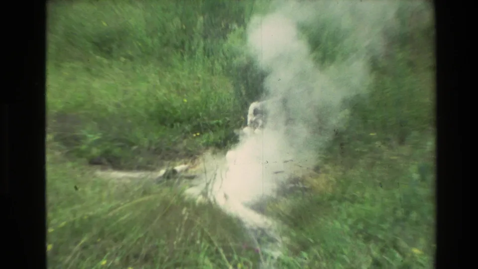 1981 New Zealand 8mm frame showing steam drifting across grass from a low geothermal vent.