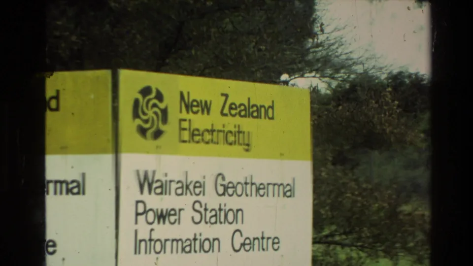 Visitor-shot 1981 New Zealand frame showing the New Zealand Electricity sign for Wairakei Geothermal Power Station Information Centre beside trees.