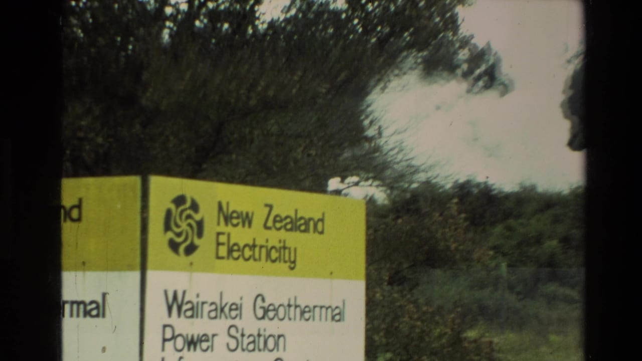 1981 New Zealand 8mm frame showing a yellow and white New Zealand Electricity sign for Wairakei Geothermal Power Station near trees.