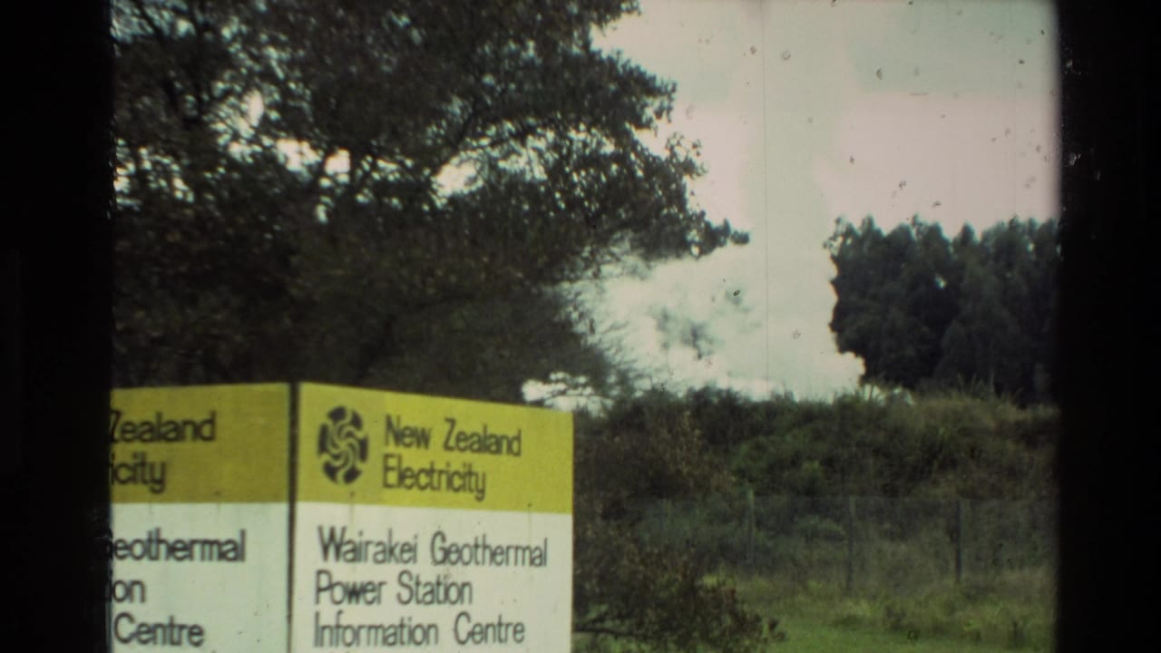 Wairakei Geothermal Power Station Information Centre sign with trees and steam behind it.