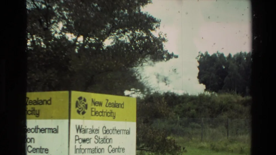 Visitor-shot 1981 New Zealand frame of the Wairakei Geothermal Power Station Information Centre sign, with vegetation and steam in the background.