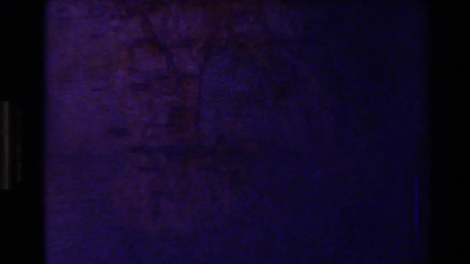 Opening 1981 8mm frame from New Zealand metadata, showing a dim projected map surface before the image becomes readable.