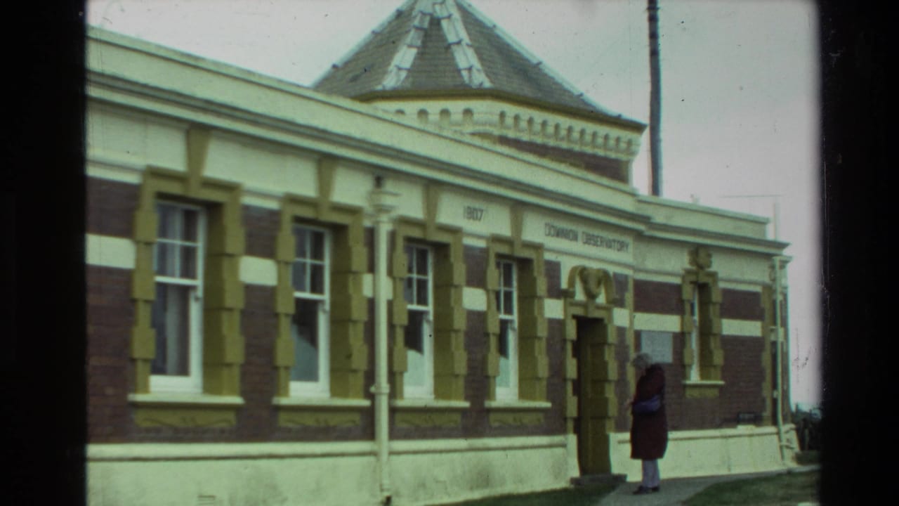 1981 New Zealand 8mm frame showing an observatory exterior with striped brickwork, arched doorway, and a visitor near the entrance.