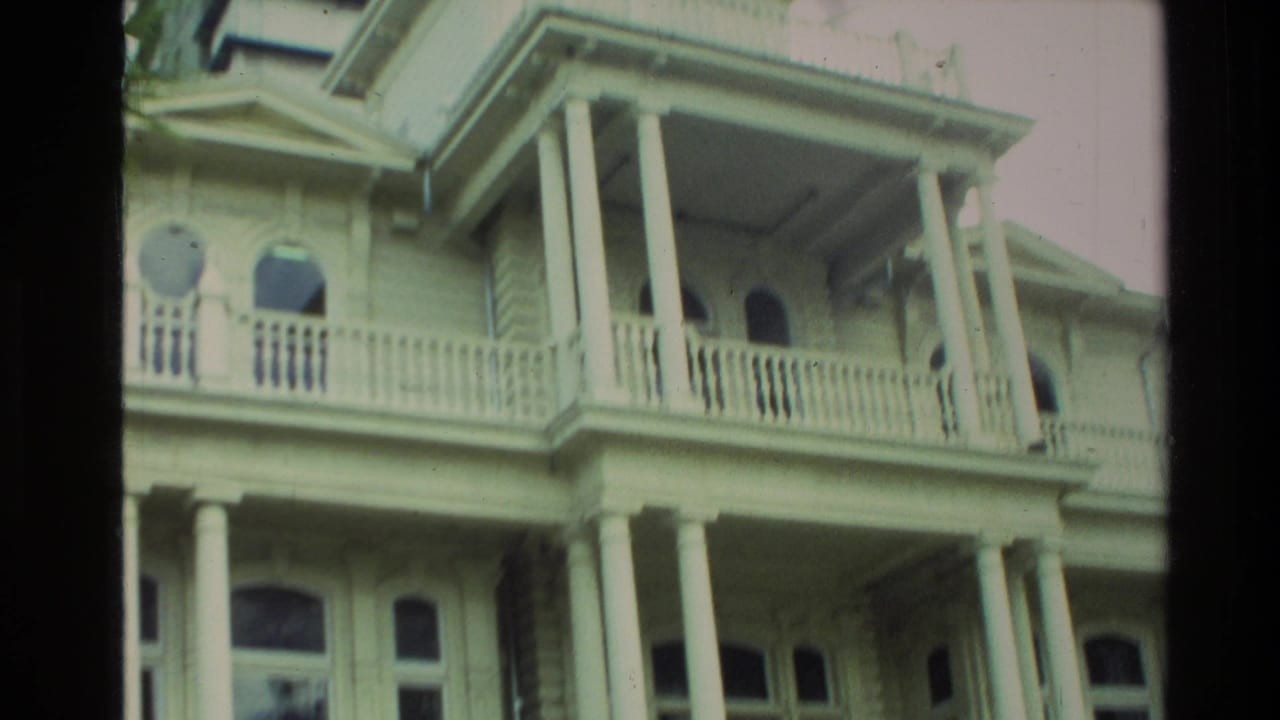 1981 New Zealand home-movie view of an ornate pale historic building with tall columns, balustrades, and arched windows.