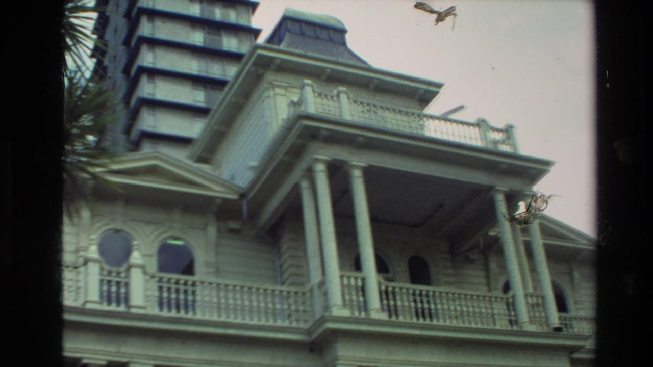 1981 New Zealand 8mm frame showing a columned historic building with arched windows and a taller building rising behind it.