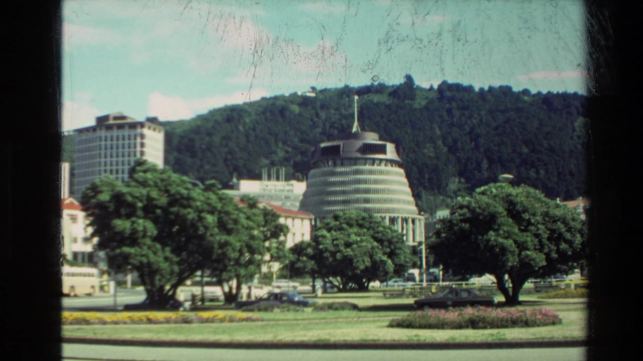 Wellington Beehive building seen across landscaped lawns and trees in 1981 New Zealand home-movie footage.
