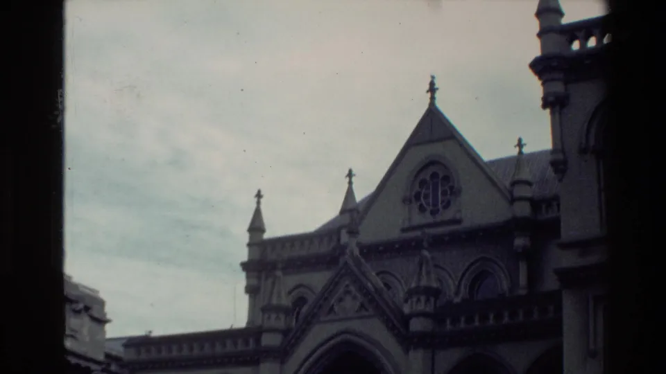 1981 New Zealand frame showing a cropped view of Gothic-style arches, a peaked gable, and surrounding stone architectural details.