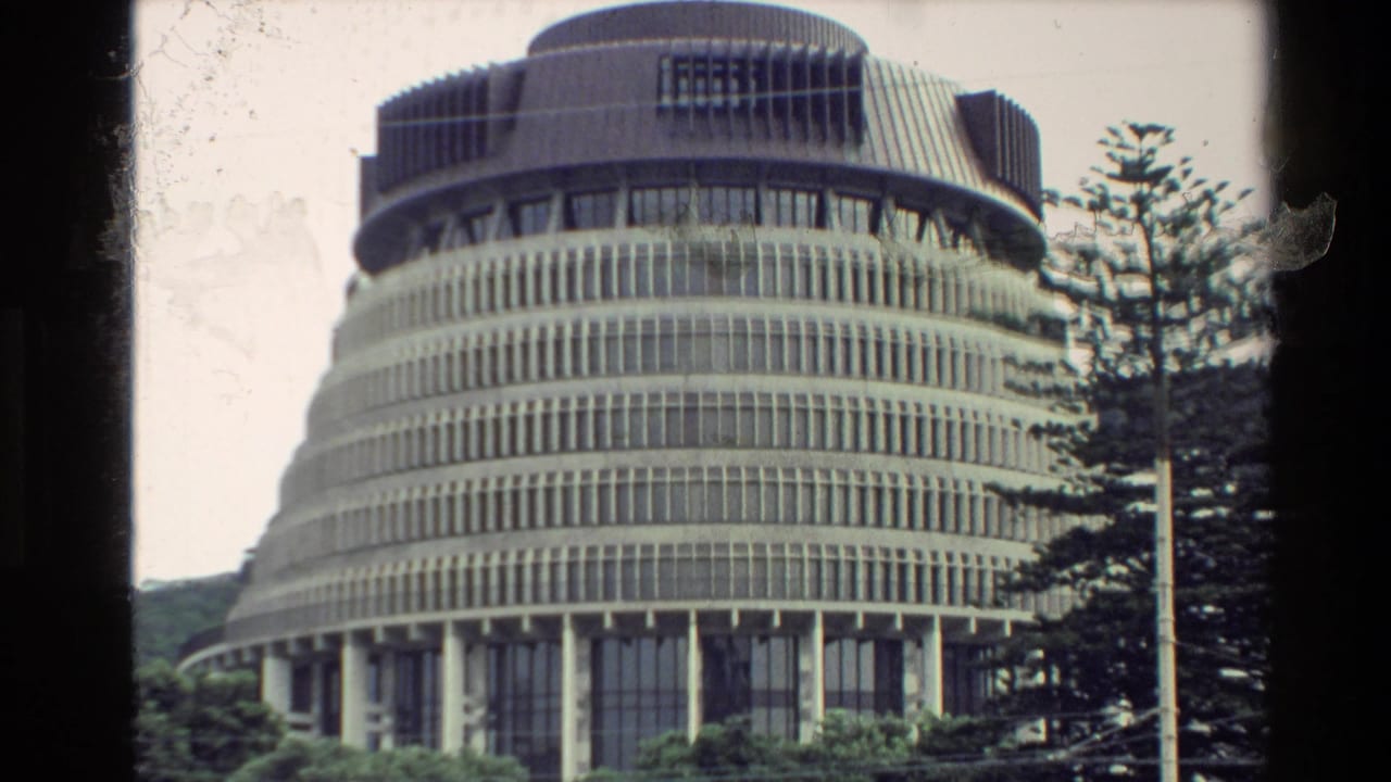 1981 New Zealand 8mm frame showing the Beehive’s circular facade, vertical windows, concrete tiers, trees, and Super 8 edge vignetting.