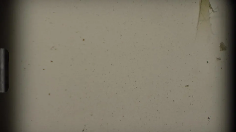 End frame from the 8mm scan, showing a pale exposed area with dust, edge shadows, and minor film wear rather than a distinct landscape view.