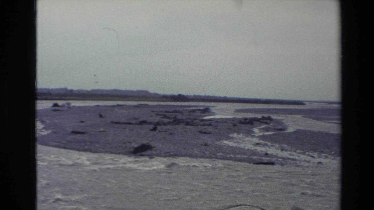 Braided river channels and gravel flats under a cloudy sky.