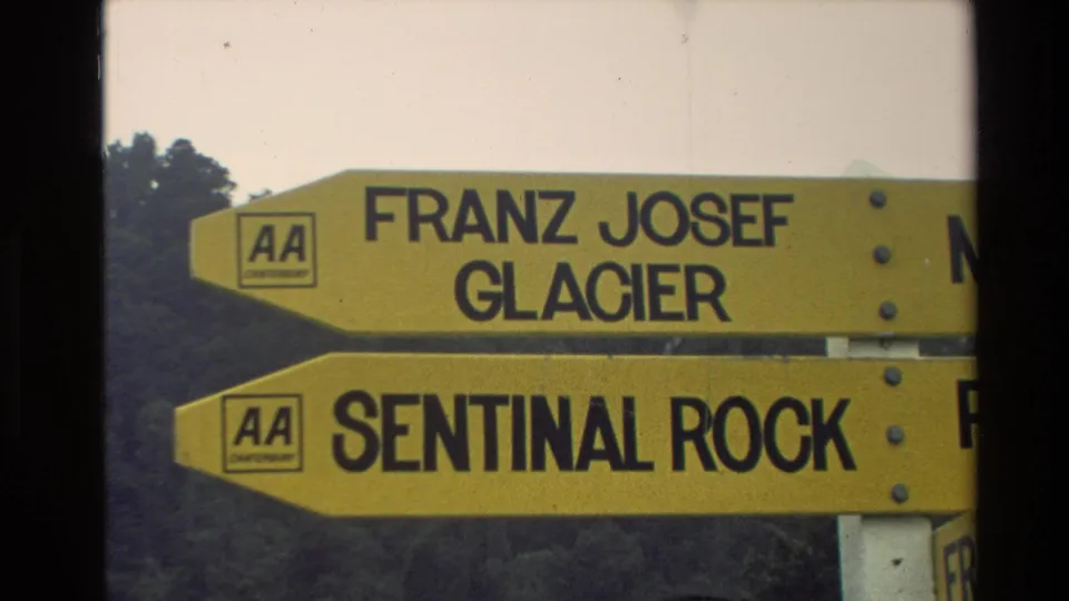 1982 New Zealand home-movie close-up of yellow directional signs naming Franz Josef Glacier and Sentinel Rock.