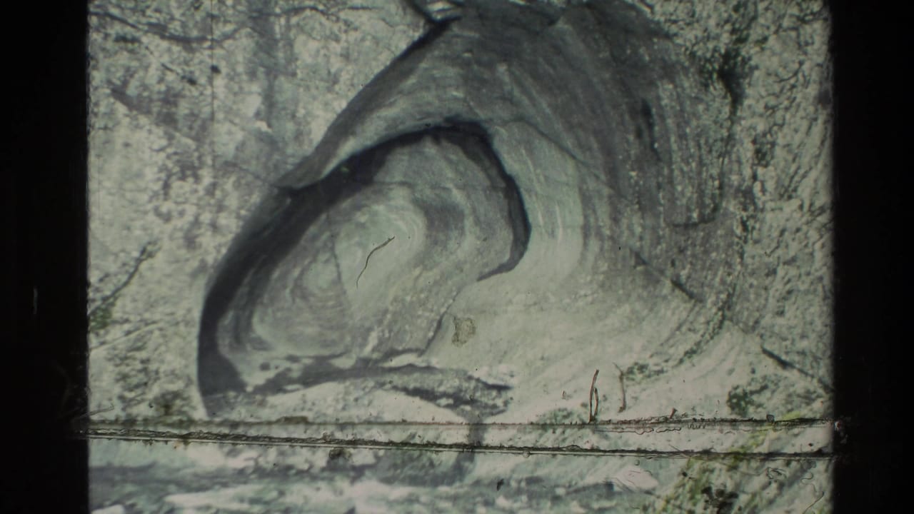 1982 New Zealand 8mm frame showing a pale eroded rock formation and rough canyon wall in soft, grainy color.