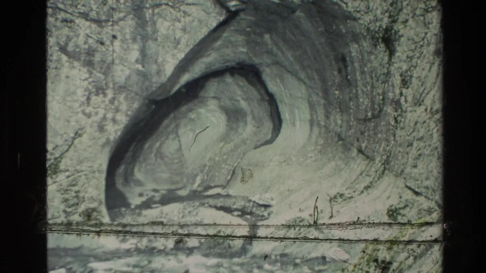 1982 New Zealand 8mm frame showing a pale eroded rock formation and rough canyon wall in soft, grainy color.