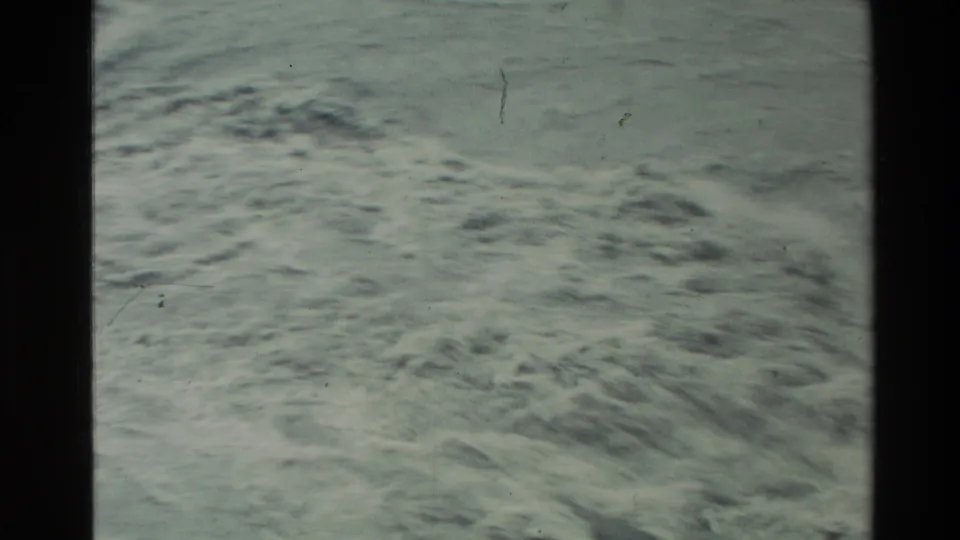 1982 New Zealand home-movie frame focused on foaming rapids and textured river water seen from a high angle.