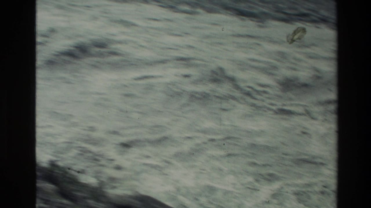 1982 New Zealand 8mm frame showing a close, abstract view of rushing water and surface ripples.