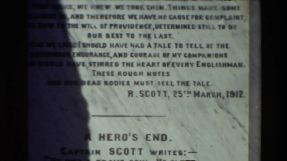 Close 8mm frame of a memorial plaque inscription, including visible Scott text and date, though the specific site needs verification.